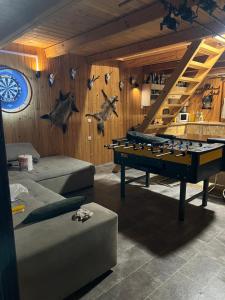 a living room with a pool table in a room at Bokodi üdülő és horgászházak in Oroszlány