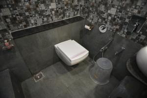a bathroom with a white toilet in a stall at Hotel Royal Residency in Vadodara +59 photos