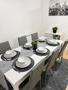a dining room table with a white tablecloth and chairs at Stylish 1-BR Apartment Perfect for 4 in Birmingham