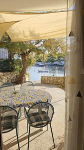 a table and chairs sitting under a tent with a view of the water at Apartment Karuza Rukavac in Vis