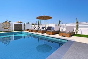 プロタラスにあるPrincess Anne Luxury Villa - Large Poolのラウンジチェアとパラソル付きのスイミングプールを併設しています。