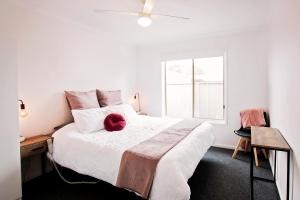 a bedroom with a large white bed with a window at Sunny Shackell - Echuca Moama Holiday Accommodation in Echuca