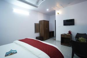 a hotel room with a bed and a television at Jags-N-Kals in Bhīm Tāl