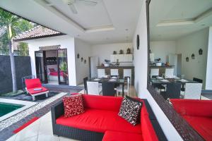 a living room with a red couch and a pool at Bali Cinta Villa in Seminyak