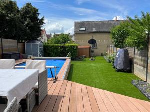 einen Hinterhof mit einem Pool und einer Holzterrasse in der Unterkunft La Maison des Rêves - 8 pers - Centre - Rêve au Mans in Le Mans
