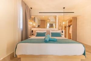 ein Schlafzimmer mit einem großen Bett, auf dem ein blaues Stofftier liegt in der Unterkunft Pegasos Deluxe Beach Hotel in Faliraki