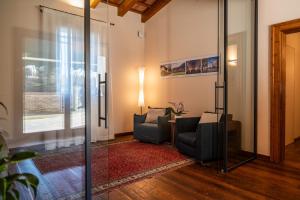 a living room with two chairs and a table at AURA Dimore ad Arquà Petrarca in Arquà Petrarca