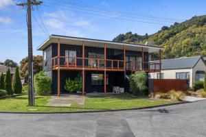 a house with a balcony on the side of a street at Coastal Charm - Picton Holiday Home in Picton