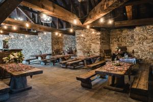 a restaurant with wooden tables and stone walls at Zamek Czocha in Leśna