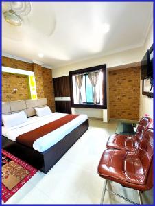 a bedroom with a large bed and a leather couch at HOTEL SAI & SAND PIPER Near Jagannath Temple - Restaurant and Parking Facilities - Fully Air Conditioning Hotel - A Top Rated Hotel in Gaya