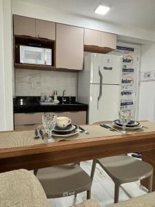 a kitchen with a table and a white refrigerator at Flat Novo no Centro de Porto de Galinhas in Porto De Galinhas +26 photos