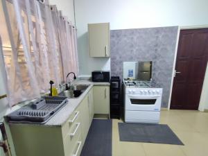 a kitchen with a sink and a stove at North Area Stay Inn in Paramaribo