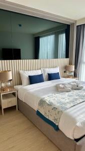a bedroom with a large bed with blue pillows at Ozone Sky View Residence in Laguna Phuket
