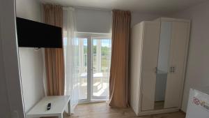 ein Wohnzimmer mit einer Glasschiebetür zu einem Balkon in der Unterkunft Casa NICORAD Camere in Pucioasa