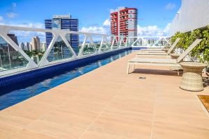 a balcony with benches on the roof of a building at Salvador Business by Avectur in Salvador