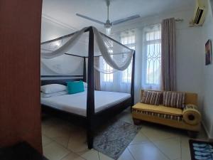 Un pat sau paturi într-o cameră la Ary Homestay Nyali- A Walk to Nyali Beach