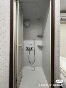 a small bathroom with a shower in a room at 依茶宿 in Matsudo