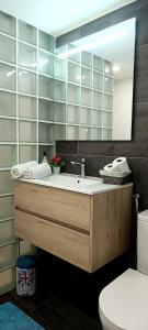 a bathroom with a sink and a mirror and a toilet at Playa del ingles Tamaran apartamento 509 in Maspalomas +10 photos