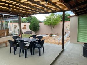 a patio with a table and chairs under a pergola at Pousada Recanto Flor da Serra in São Roque de Minas