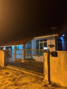 una casa con una recinzione di fronte ad essa di notte di Homestay Kita Kg Bechah Keranji a Ketereh