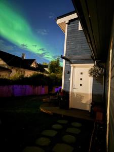 a small house with a white door in a yard at luxury Apartment by Skyactive in Tromsø