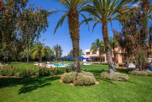 a yard with three palm trees and a swimming pool at Palais pyar in Najem