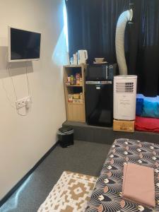 a room with a bed and a tv and a room with at Chambre indépendante tout confort in Boé