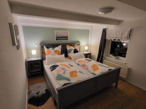 a bedroom with a large bed with pillows at Gemütliche Ferienwohnung unter Reet in Ahrenshöft
