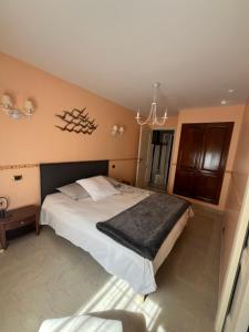 a bedroom with a large bed and a chandelier at Côt’et Calme in Saint Malo