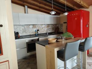 a kitchen with white cabinets and a red refrigerator at Bioagriturismo Podere Ruggeri in Pontassieve