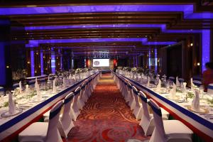 a long banquet hall with white tables and chairs at Chengdu Tibetan Hotel in Chengdu