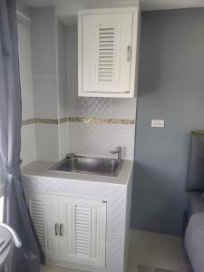 a kitchen with a sink and a white cabinet at Nirun Condo Pattaya in Ban Nong Chaeng