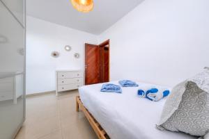 a bedroom with a white bed with blue pillows at The mermaid House- Playa Honda in Playa Honda
