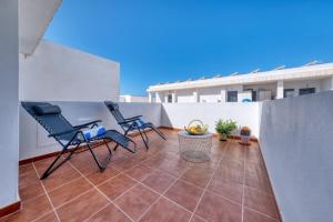 a patio with two chairs and a table on a balcony at The mermaid House- Playa Honda in Playa Honda