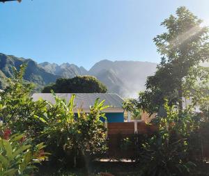 a house with a mountain in the background at kaz frangipanier in Entre-Deux