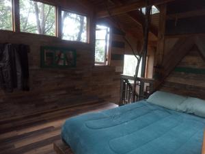 a bedroom with a bed in a wooden cabin at Cabaña cajón del Maipo in San José de Maipo