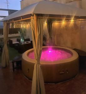 a hot tub in a patio with an umbrella at LA CASA DE LA ABUELA DESI in Casavieja