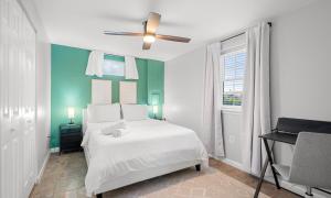 ein Schlafzimmer mit einem weißen Bett und einem Deckenventilator in der Unterkunft The Emerald Grand Old Town Views in Belle Haven