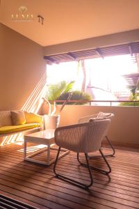 un soggiorno con due sedie e un tavolo di Appartement de Luxe au Domaine des Alizées Club & Spa, Grand Baie a Grand Baie