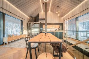a dining room with a table and some windows at Luxury Villa Valo by Hilla Villas in Kittilä
