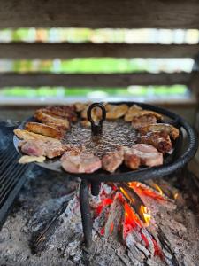 a bunch of meat and sausages on a grill at Casa tradițională Eridav in Arcani