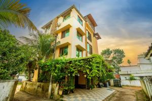 a tall yellow building with a lot of plants at Oasis Homestay Kochi in Ernakulam