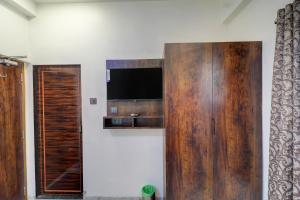 a large wooden cabinet with a television on a wall at Krishna Residency in Navi Mumbai