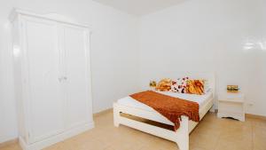a white bedroom with a bed and a white closet at Keur Maï in Dakar