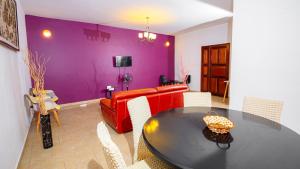 a living room with a table and a red couch at Keur Maï in Dakar