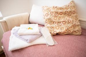 una pila de toallas y una almohada en la cama en Zimmer in Künstlerwohnung, en Stuttgart