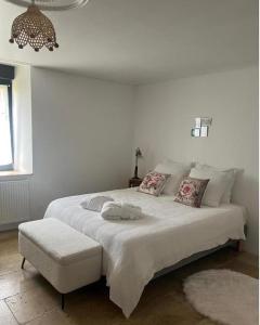 a bedroom with a large white bed with a stool at Maison 1838 