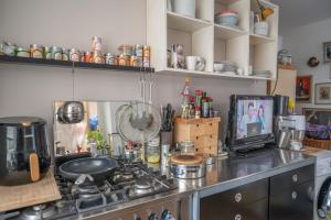 cocina con fogones y TV en la barra en Zimmer in Künstlerwohnung, en Stuttgart 6 fotos más