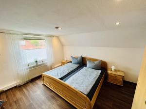 una camera da letto con un letto e una finestra di NEU! Ferienwohnung Tant Anni mit Saunaoption a Ihlow