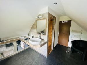 un bagno con lavandino e specchio di NEU! Ferienwohnung Tant Anni mit Saunaoption a Ihlow